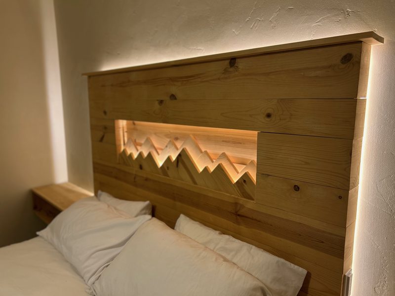 Detail of custom pine mountain silhouette headboard with LED backlighting