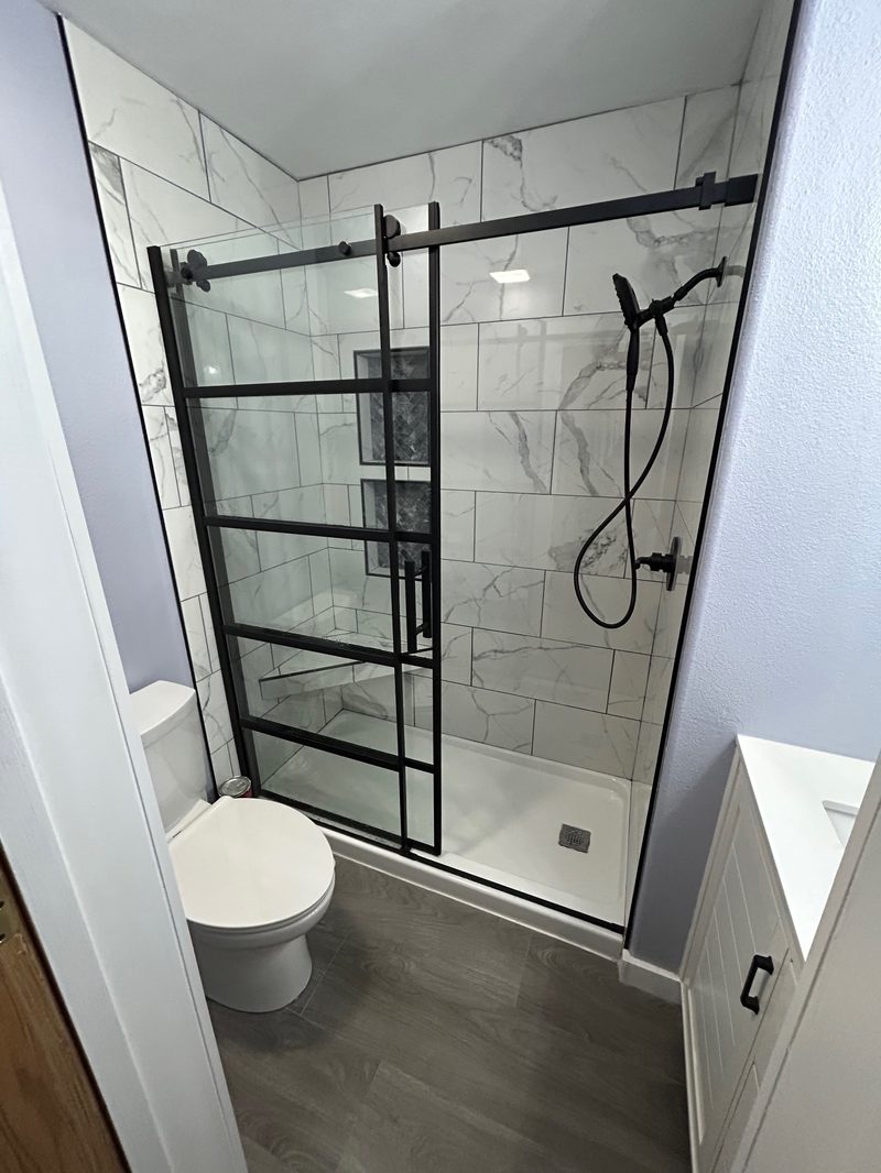 Full bathroom remodel with black-frame glass shower and marble tile in American Fork, Utah