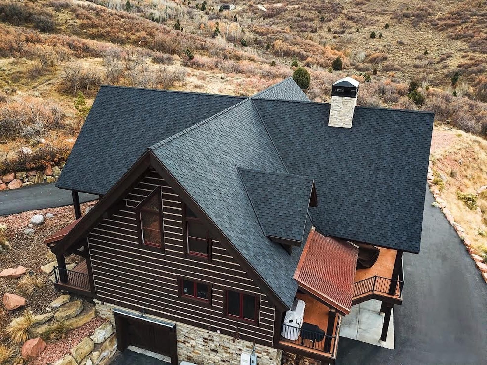 Aerial view of a custom mountain home built by PrimeWest Construction in Alpine, Utah with architectural shingle roof and timber deck